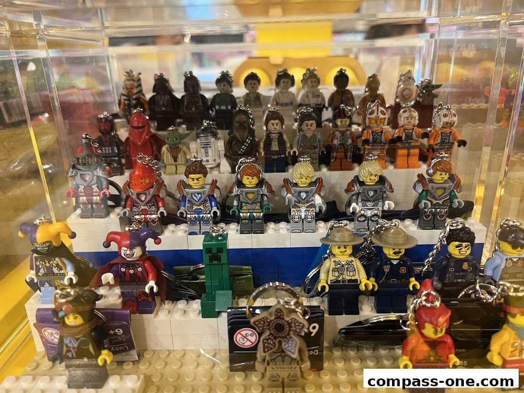 A display case filled with various LEGO minifigures, including Star Wars characters and other themed figures.