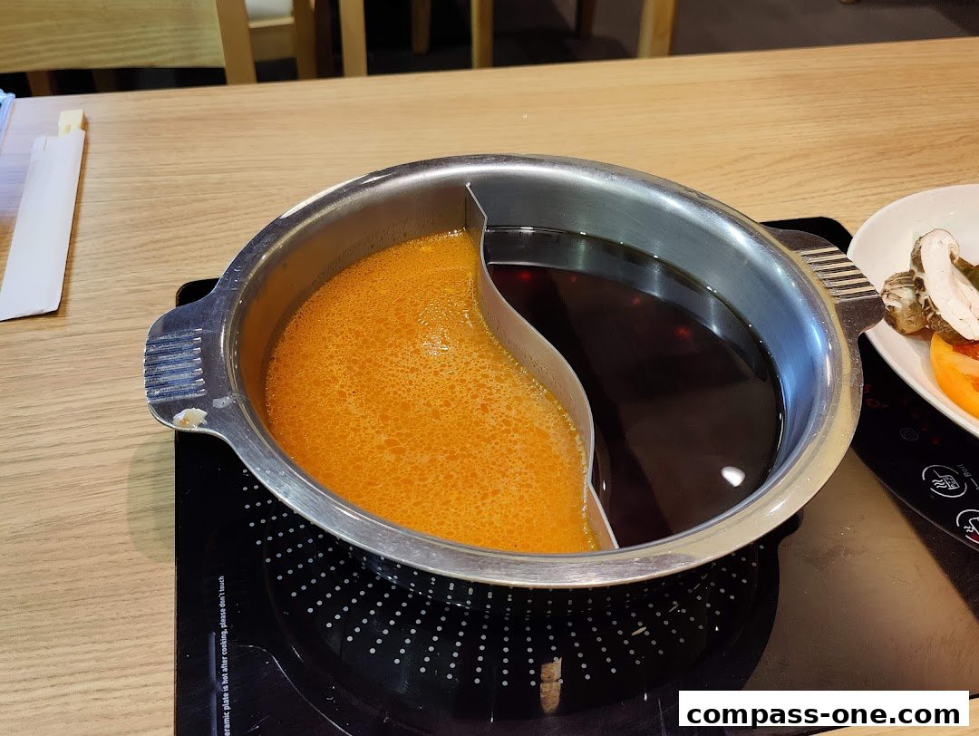 A split pot of broth sits on an induction cooker, ready for shabu-shabu.