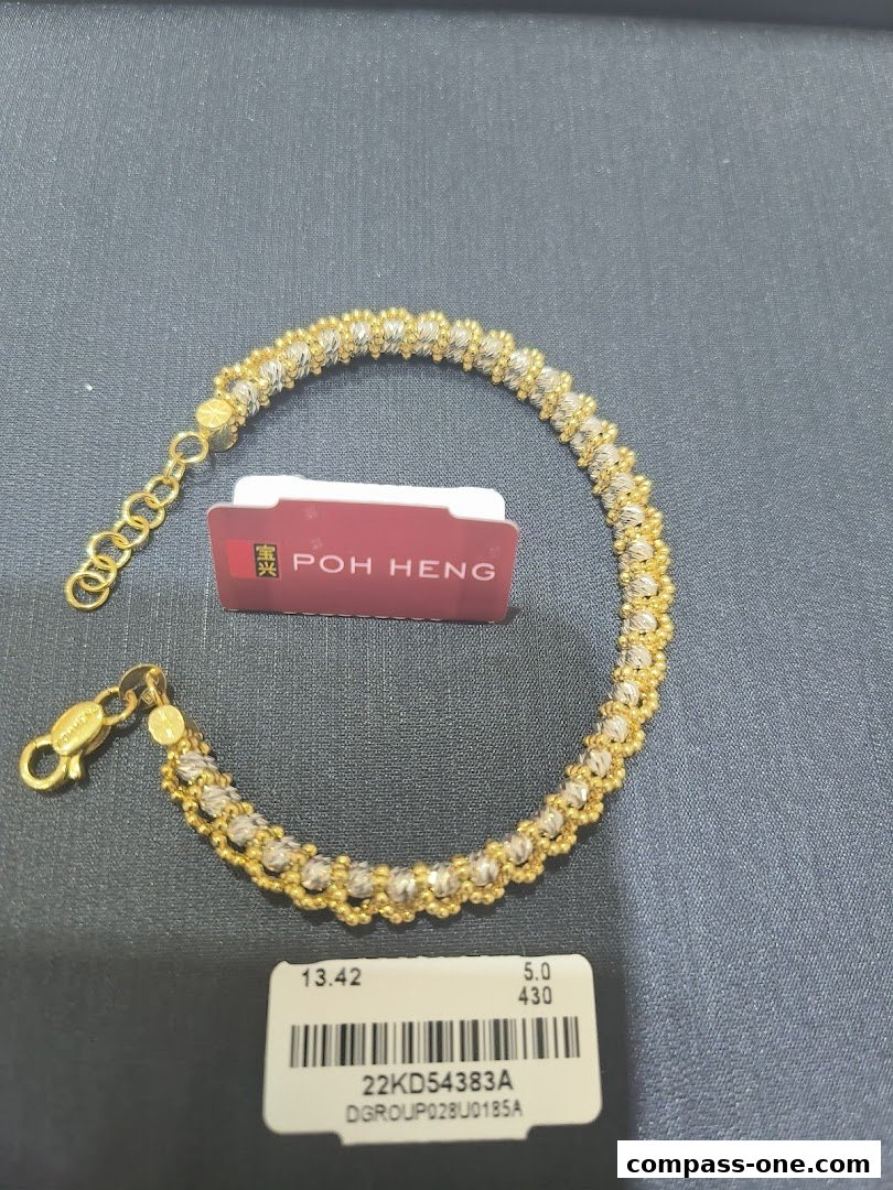 A gold and silver beaded bracelet with a Poh Heng Jewellery tag and product information label.