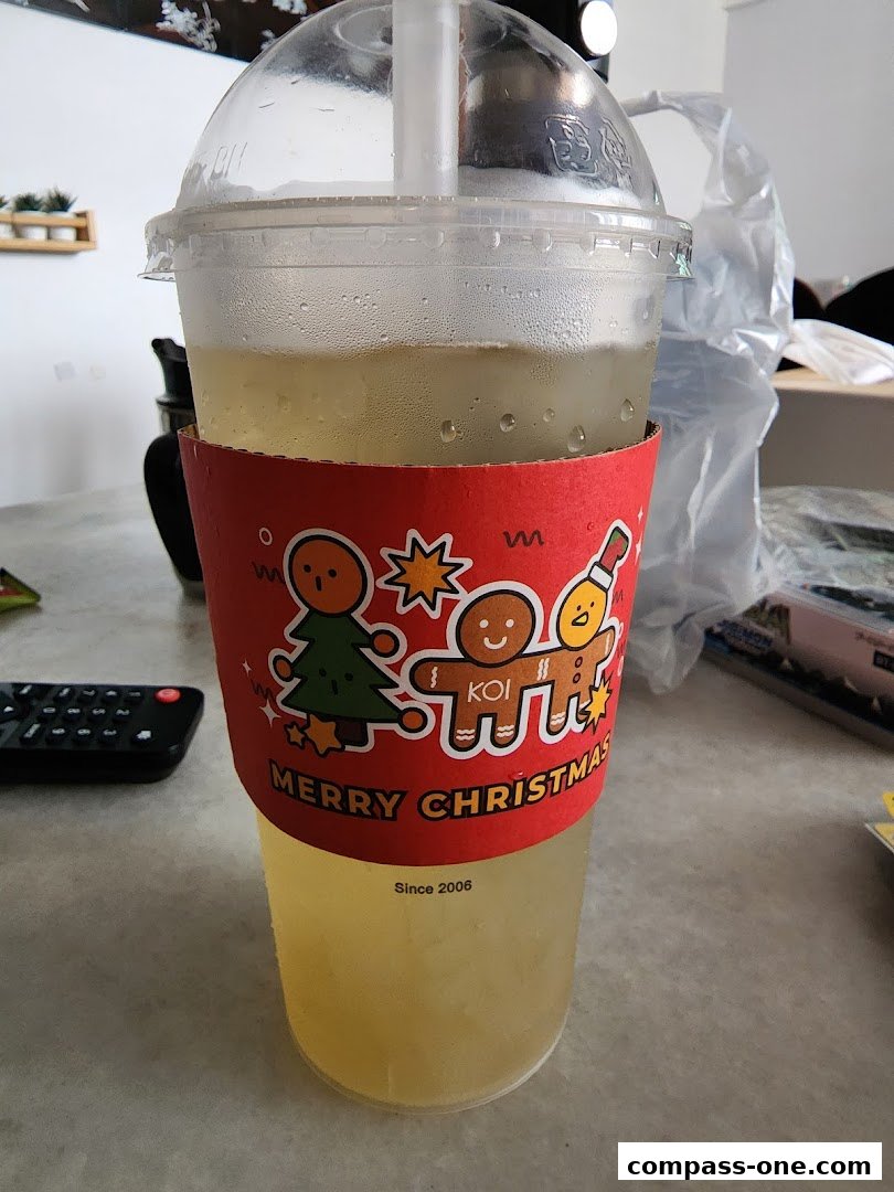 A KOI Thé drink with a festive Christmas-themed sleeve.