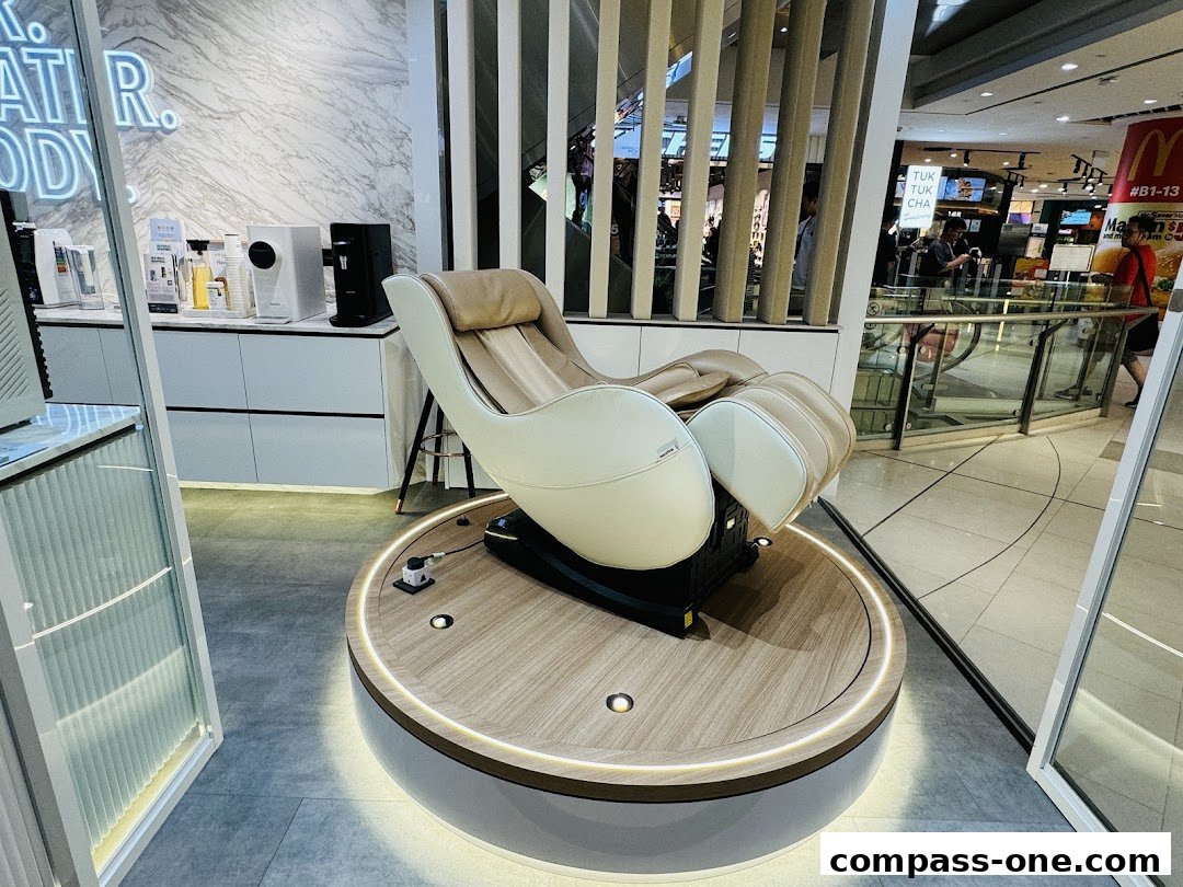 A luxurious massage chair is displayed on a circular platform in a modern retail store.