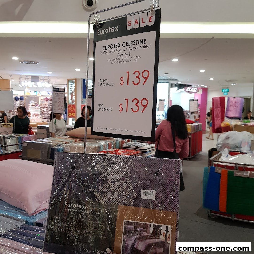 A sale sign for Eurotex bedsets is displayed in a retail store with bedding products.