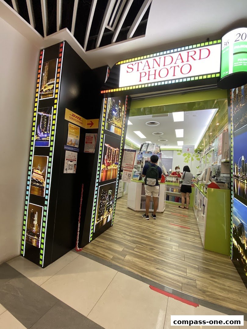 Entrance to a DHL Express Service Point and Standard Photo shop with city skyline imagery.