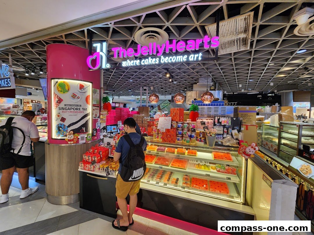 A shop display featuring colorful jelly cheesecakes and other desserts.