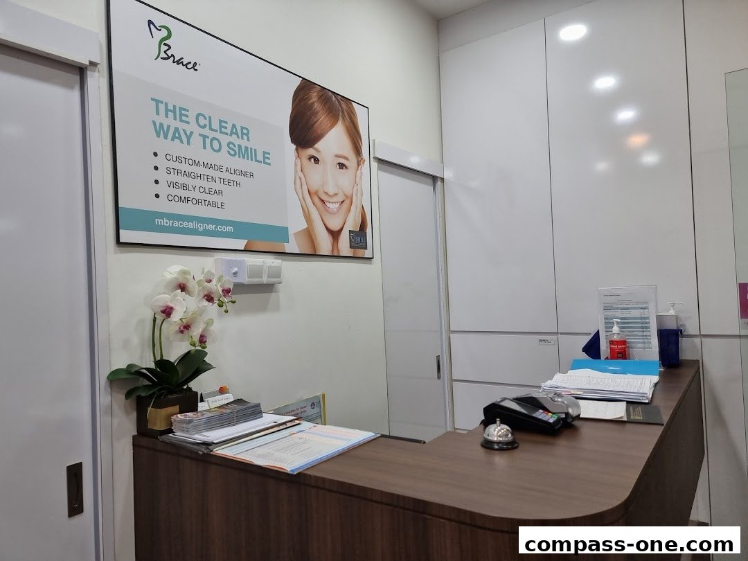 The reception desk of iSmile Dental Surgery with a promotional poster and a plant.