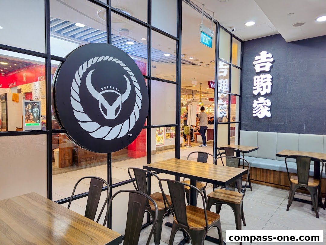 Interior view of Yoshinoya restaurant with tables, chairs, and branding.