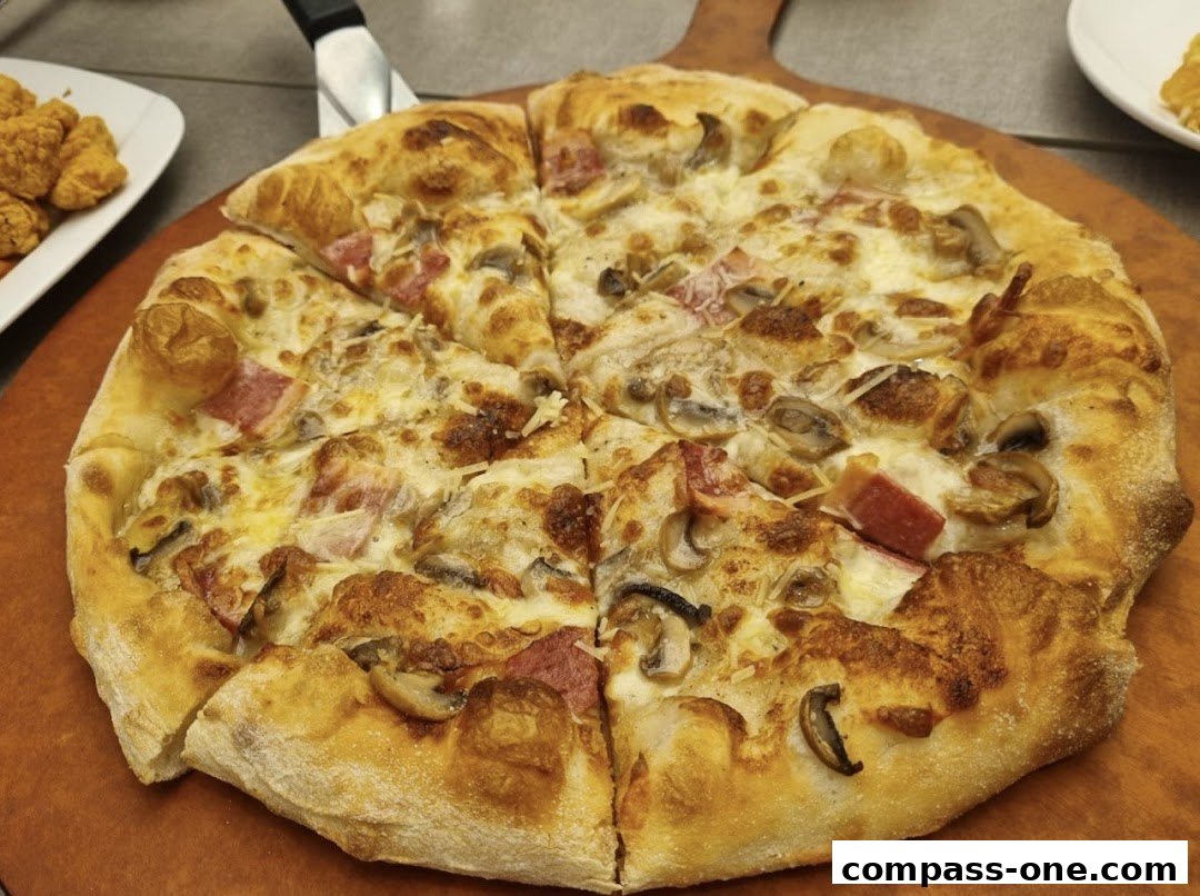 A delicious Pizza Hut pizza with mushrooms and ham, ready to be served.