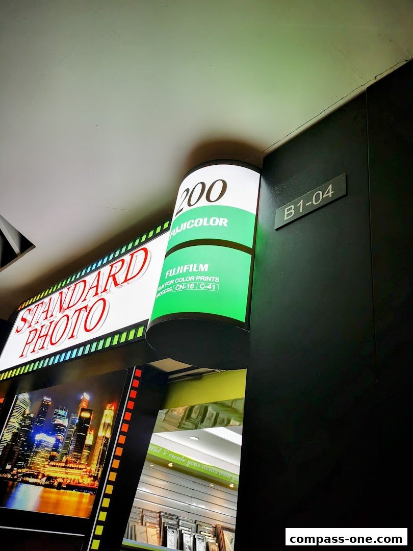 The exterior of a photo shop with a large illuminated sign and film roll display.