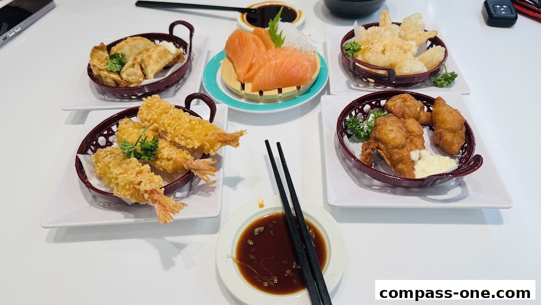 A table laden with various Japanese dishes including sashimi, fried shrimp, fried chicken, and dumplings.
