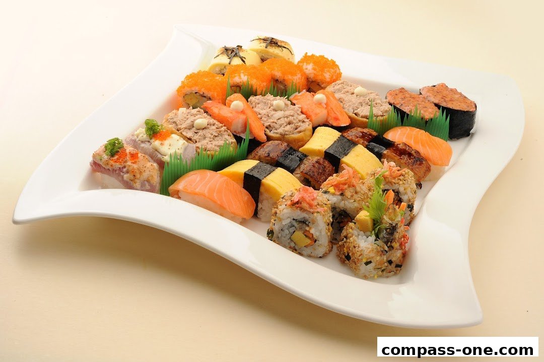 A large platter of assorted sushi and maki rolls, beautifully arranged on a white plate.