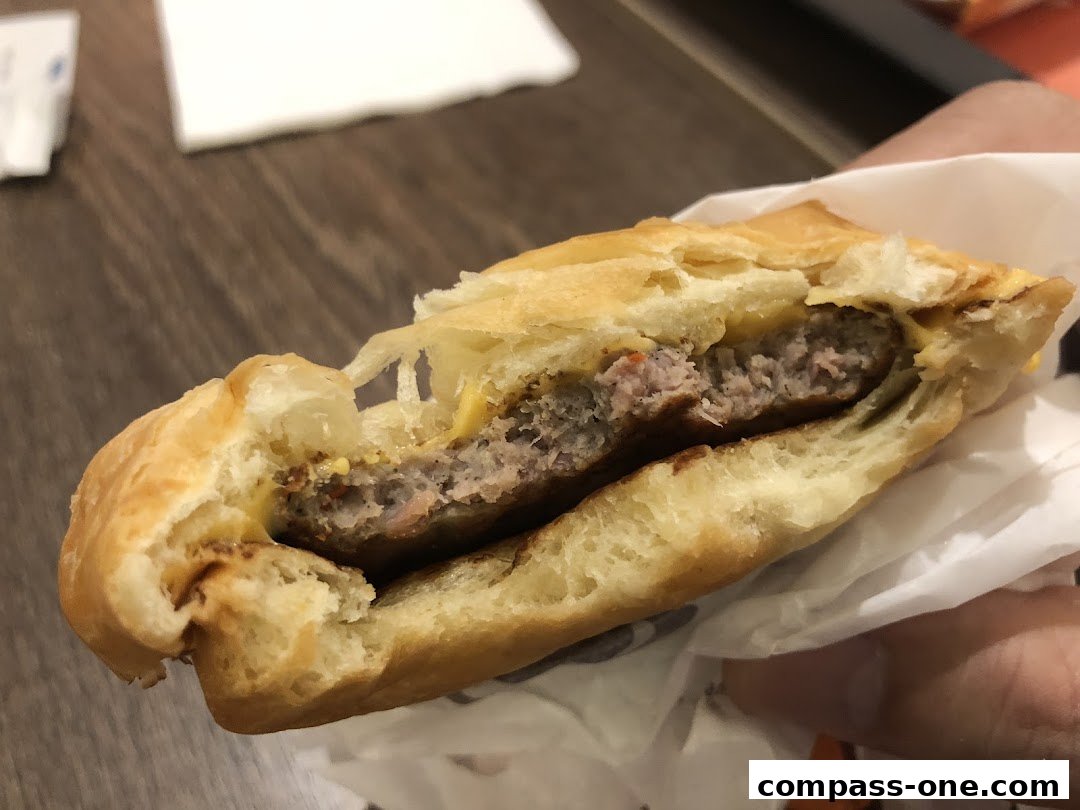 A close-up shot of a juicy burger with melted cheese, held in a wrapper.