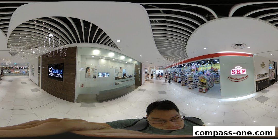 The exterior of iSmile Dental Surgery and a neighboring SKP store in a shopping mall.