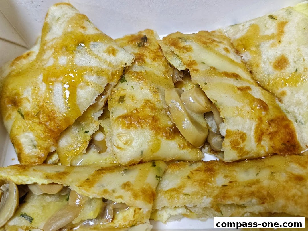 Close-up of delicious Taiwanese crepes filled with mushrooms and sauce.