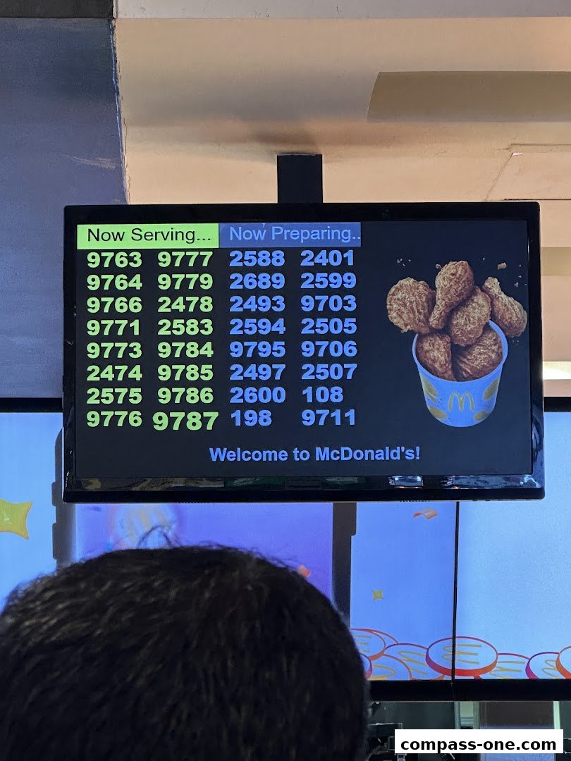 A screen displaying order numbers for 'Now Serving' and 'Now Preparing' at McDonald's.