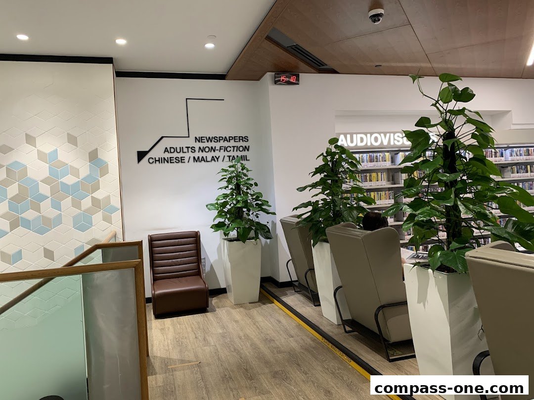 Interior of a library with seating, plants, and bookshelves.