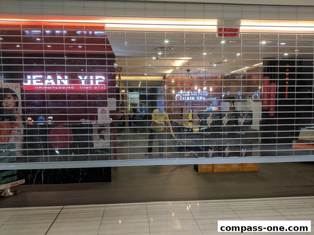 The Jean Yip Hairdressing and Hair Spa shop front with its roller shutter partially down.