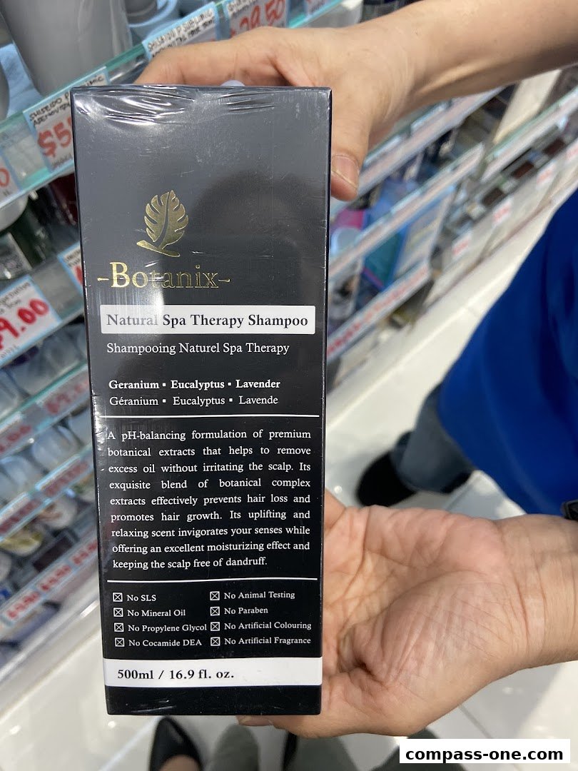A person holds a box of Botanix Natural Spa Therapy Shampoo, showcasing its benefits and ingredients.