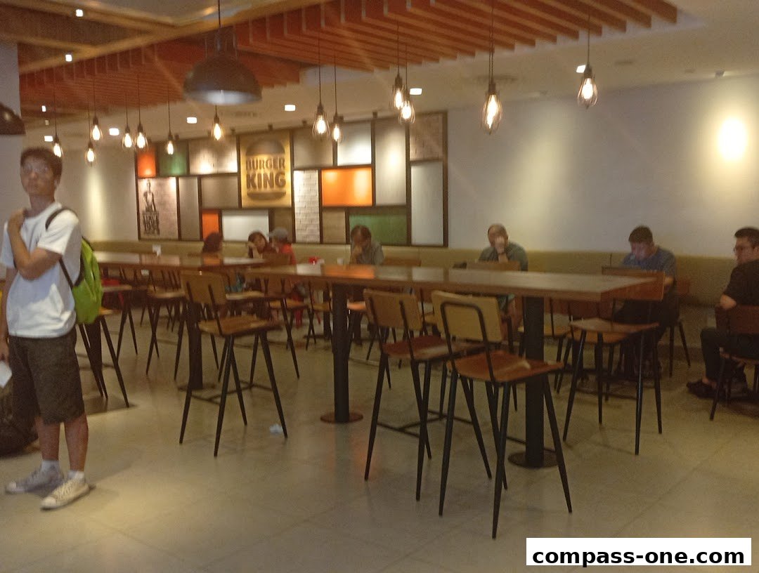 Interior of a Burger King restaurant with customers seated at tables.