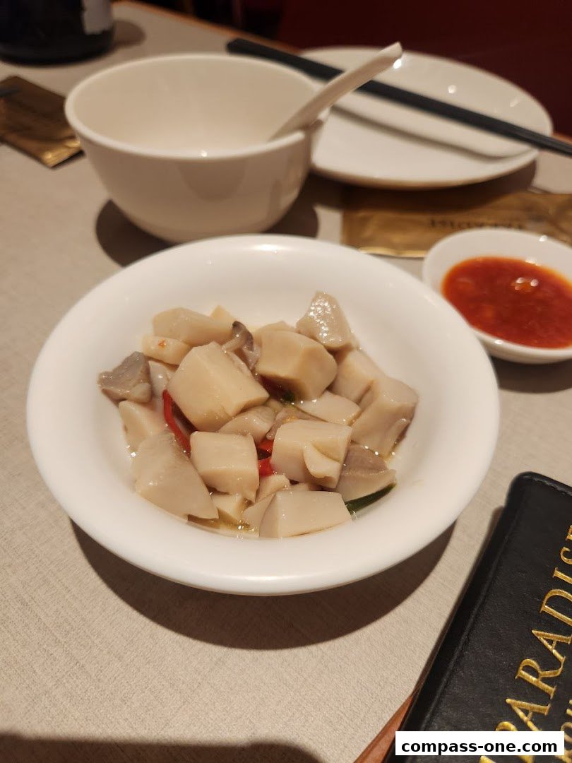 A close-up of a dish with chopped ingredients and chili, served with a side of dipping sauce.