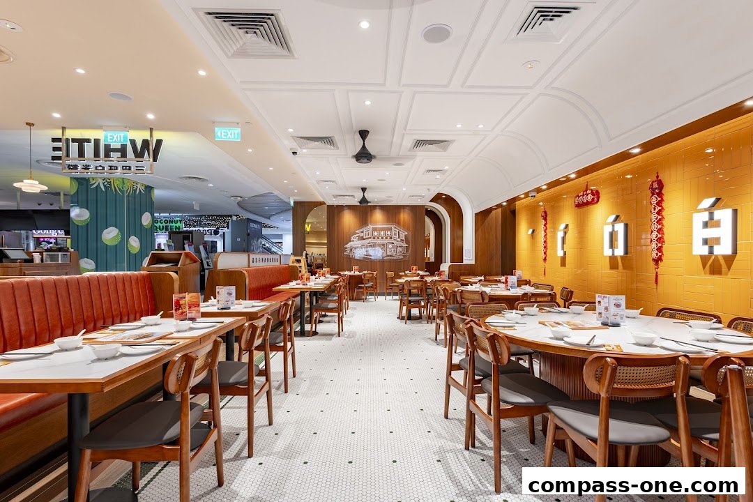 Interior view of White Restaurant with dining tables, chairs, and decorative elements.
