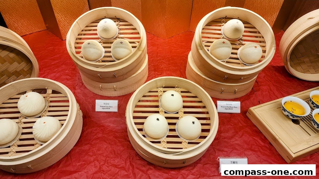 Steamed buns in bamboo steamers, with small bowls of yellow dessert on a wooden tray.