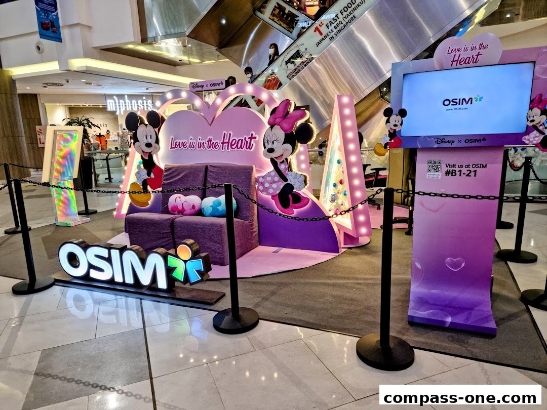 OSIM shop display featuring Mickey and Minnie Mouse with a 'Love is in the Heart' theme.