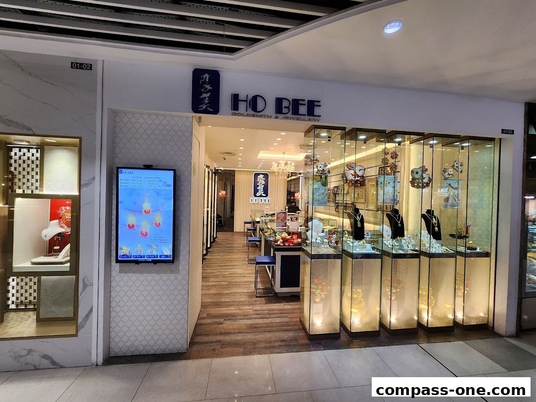 The Ho Bee Goldsmith & Jewellery shop front with illuminated display cases showcasing necklaces and jewelry.