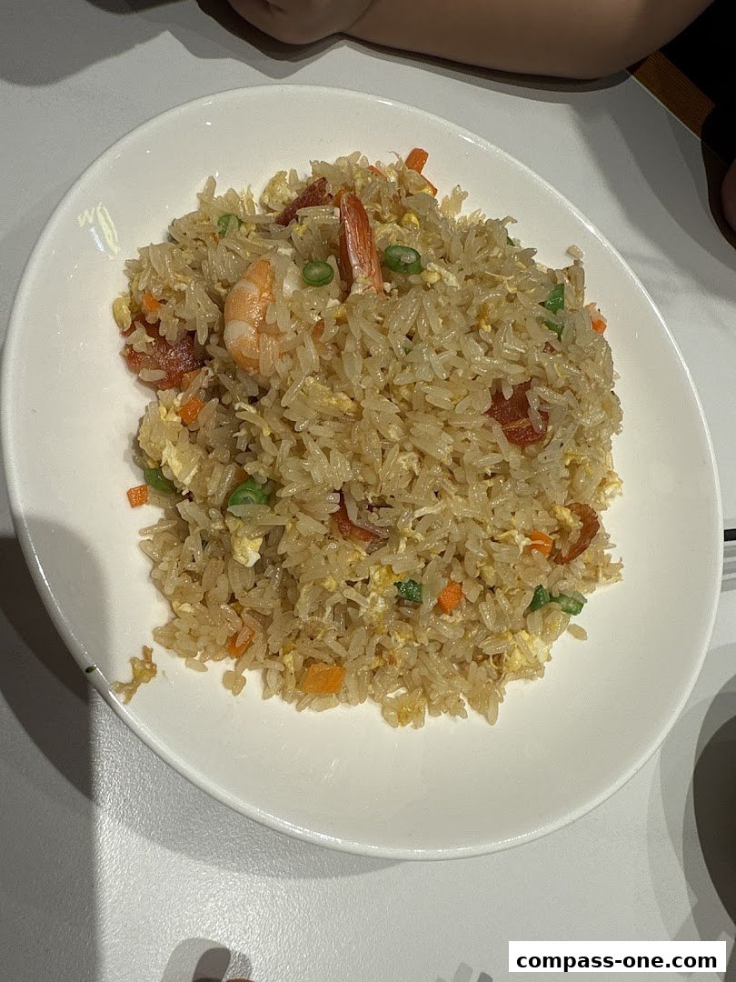 A plate of delicious fried rice with shrimp, vegetables, and meat.