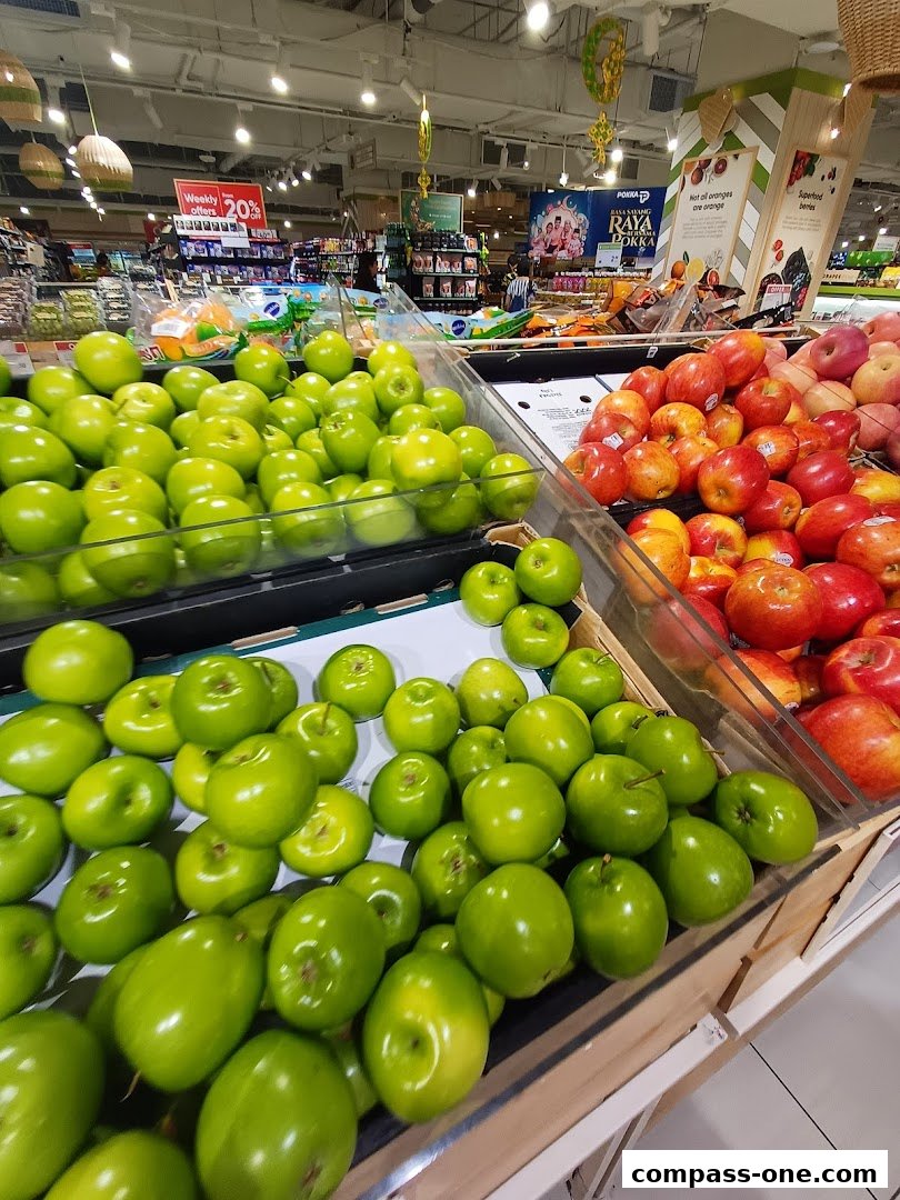 A display of fresh green apples and red apples in a supermarket produce section.