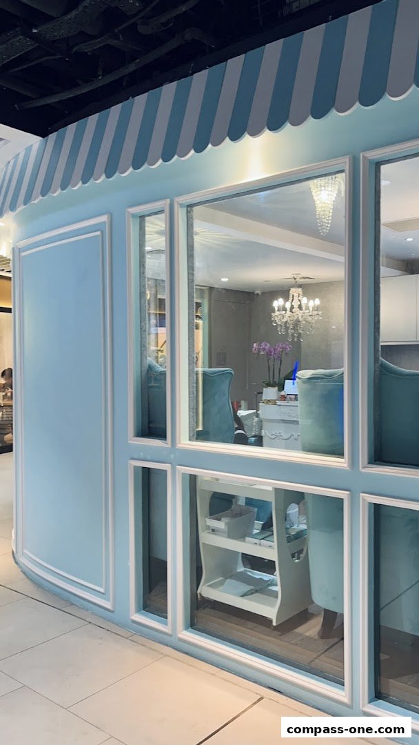 The exterior of Kawaii Nails, a pastel blue shop with a striped awning and large windows.