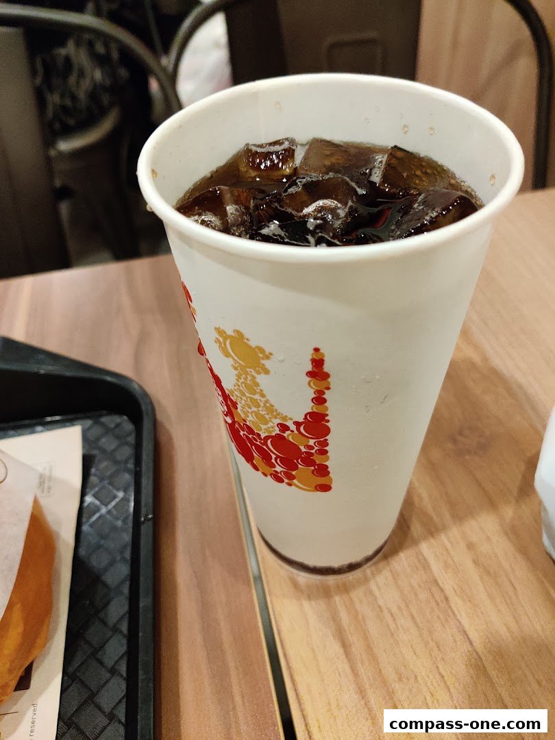 A close-up of a Burger King branded cup filled with a dark beverage and ice.