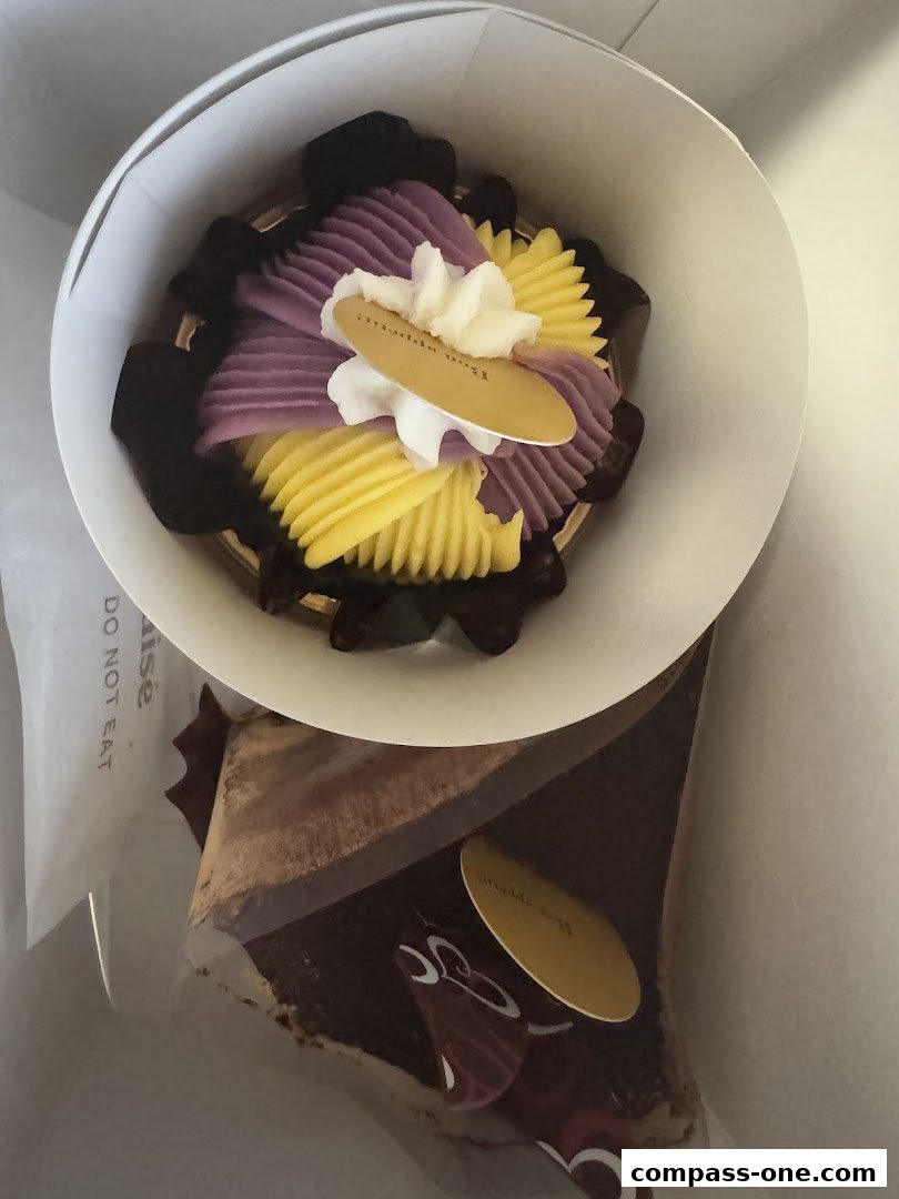 A close-up of two beautifully decorated cakes from Châteraisé, one with purple and yellow frosting.