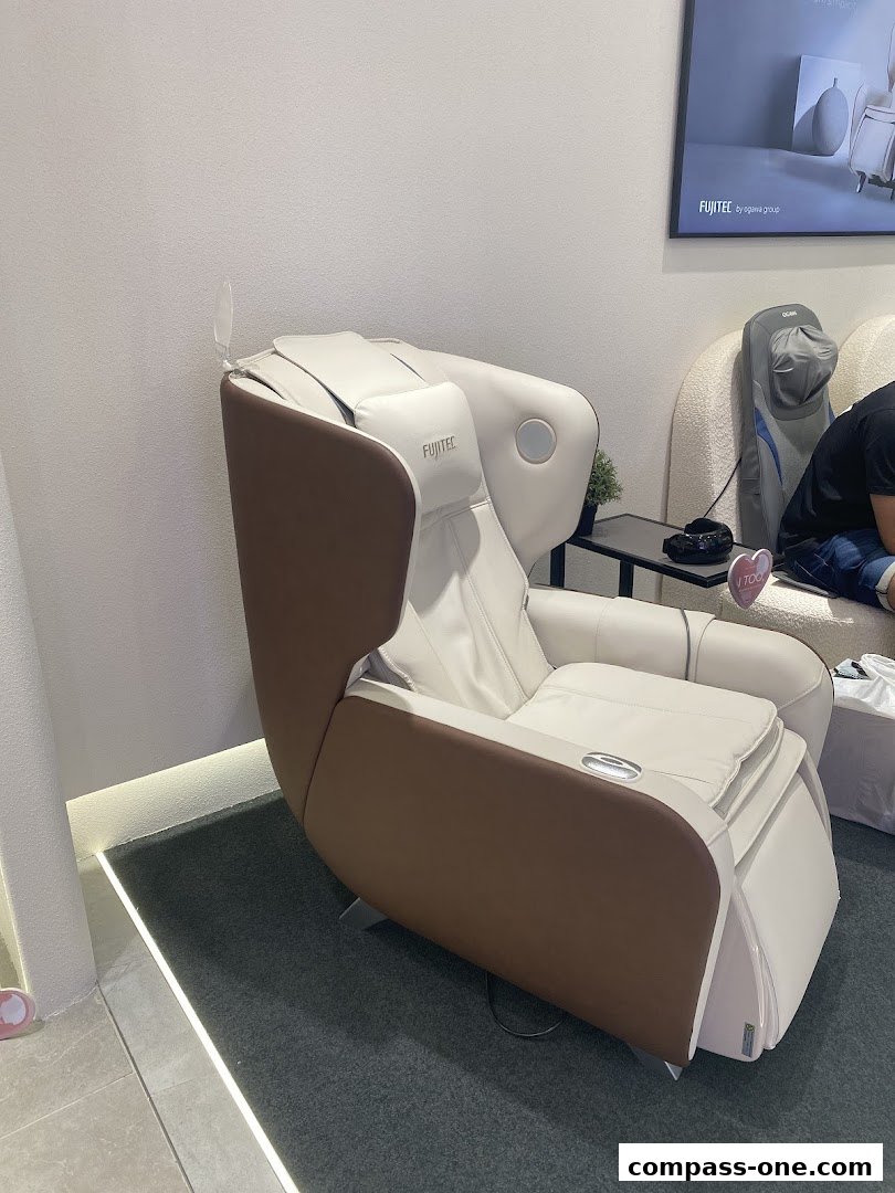 A white and brown massage chair with the Fujitec logo is displayed in a store.