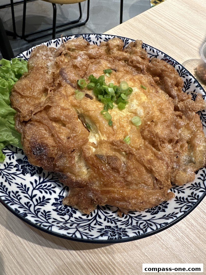 A golden-brown omelet with chopped green onions on a decorative plate with lettuce.