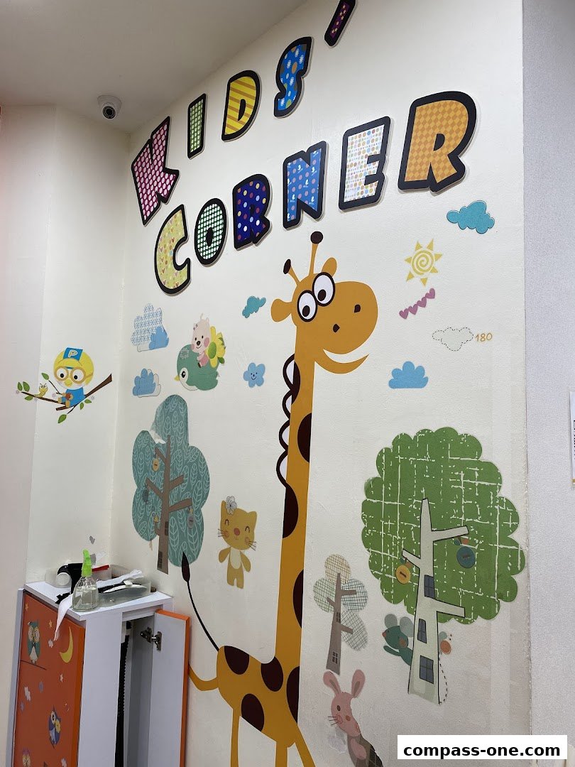 A wall decorated with colorful 'KIDS' CORNER' lettering and cartoon animal decals.