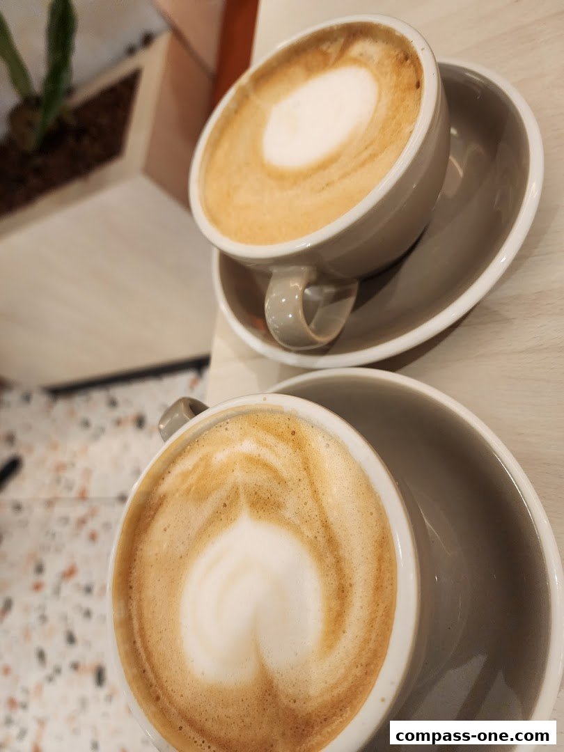 Two cups of coffee with latte art on a table at Cedele Bakery Cafe.