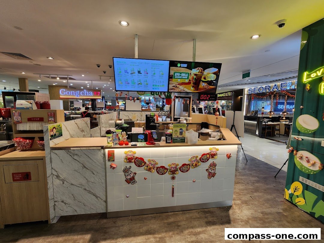 The Coconut Queen shop counter with a digital menu board and festive decorations.
