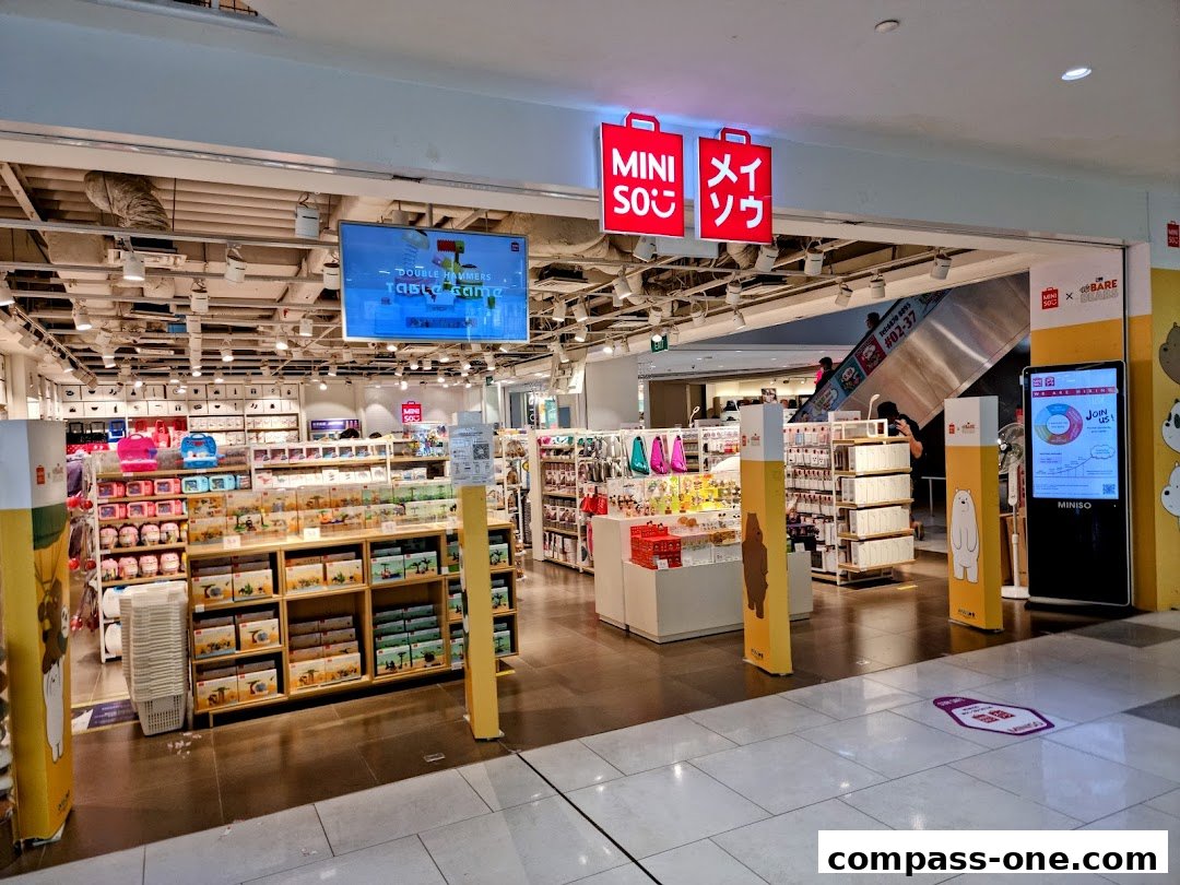 The entrance and interior of a MINISO store filled with various products and displays.