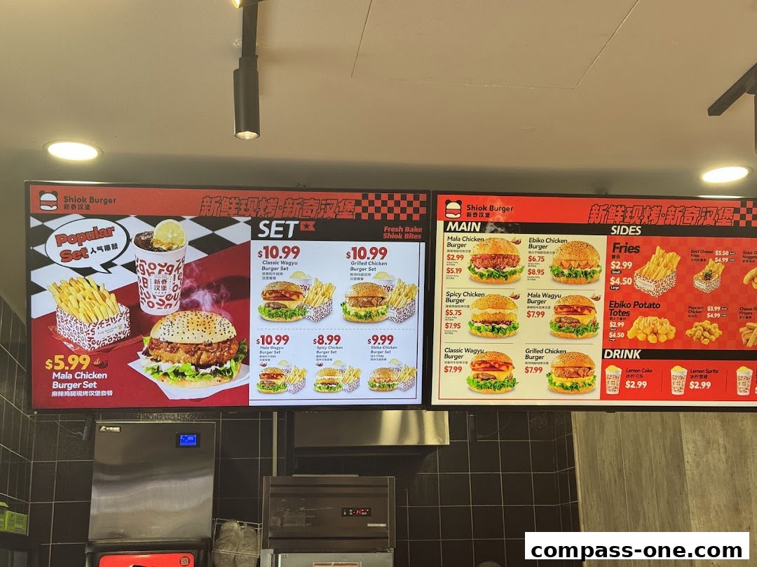 A digital menu board displaying various burger sets, main courses, sides, and drinks from Shiok Burger.