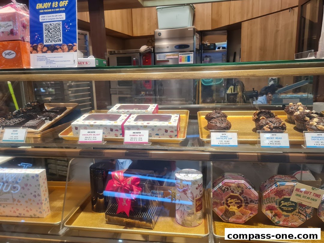 A display case filled with various cookies, muffins, and gift tins from Famous Amos.