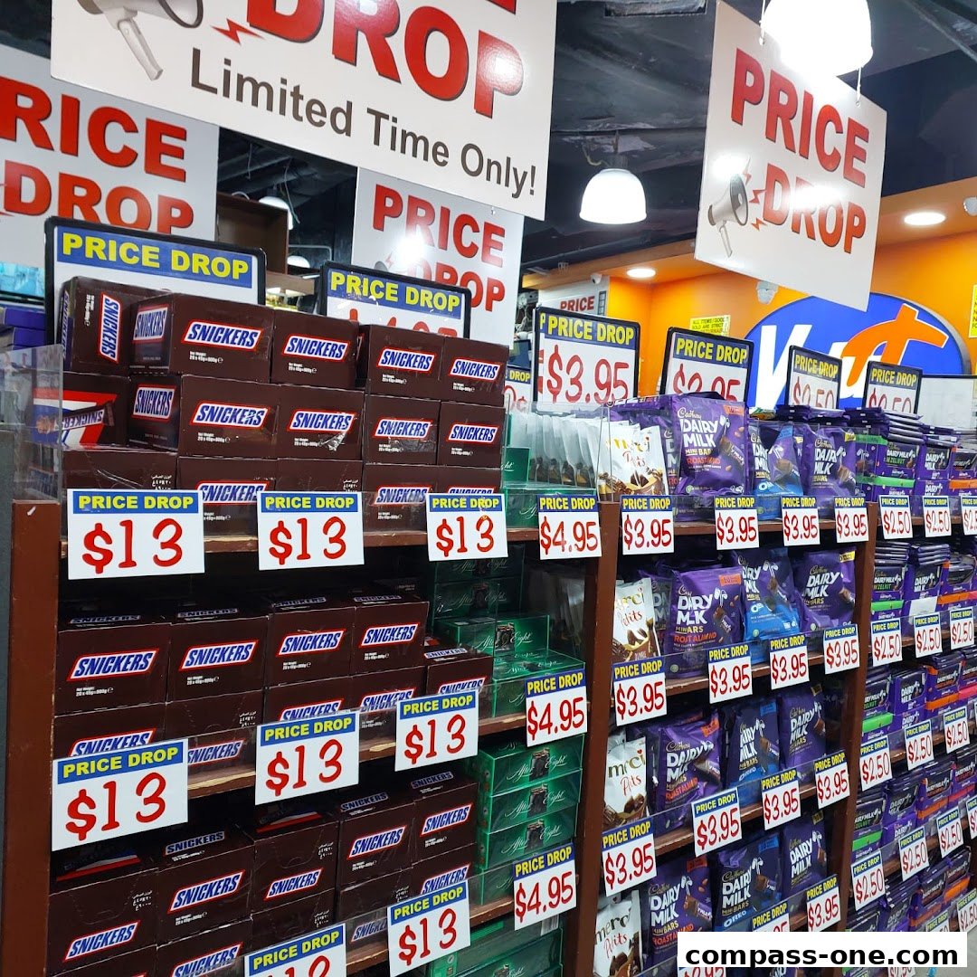 Shelves stocked with Snickers and Cadbury Dairy Milk chocolate bars on sale.