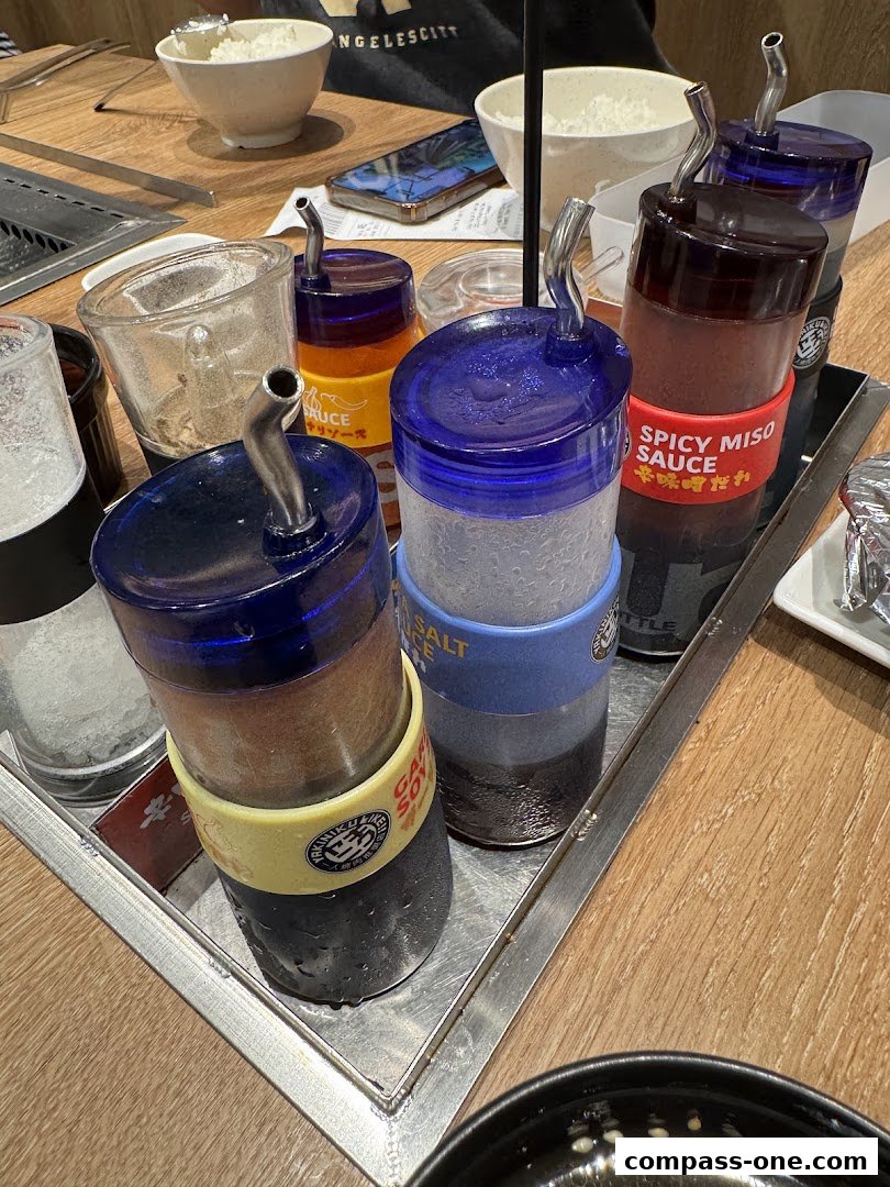 A close-up of various sauce bottles and condiments on a table at a restaurant.