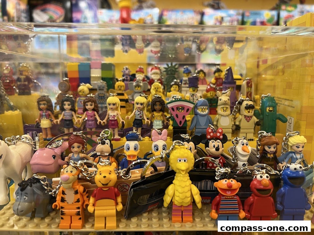 A display of various LEGO minifigure keychains featuring popular characters from Disney and Sesame Street.