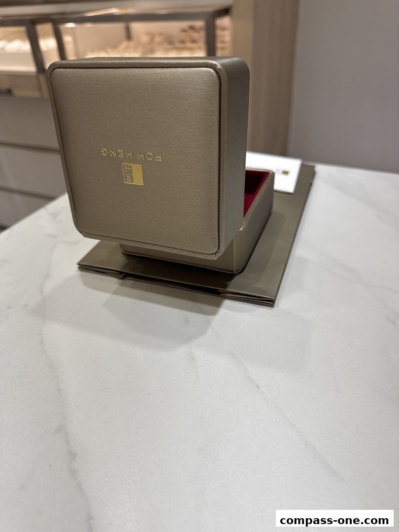 A luxurious jewelry box from Poh Heng Jewellery is displayed on a marble surface.