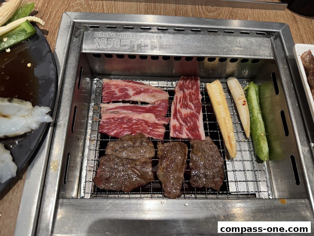 A close-up of a Yakiniku grill with various cuts of beef, corn, and green peppers.