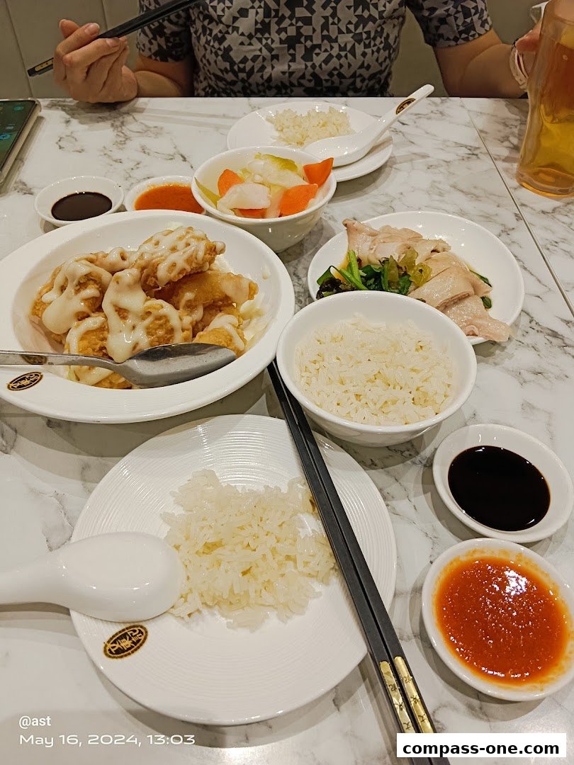 A table laden with delicious Boon Tong Kee dishes, including chicken rice and fried chicken.