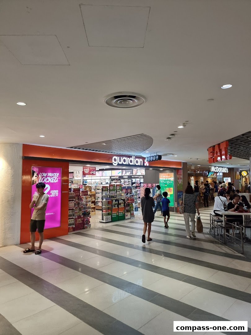 The Guardian Health & Beauty store entrance with products displayed inside and people walking by.