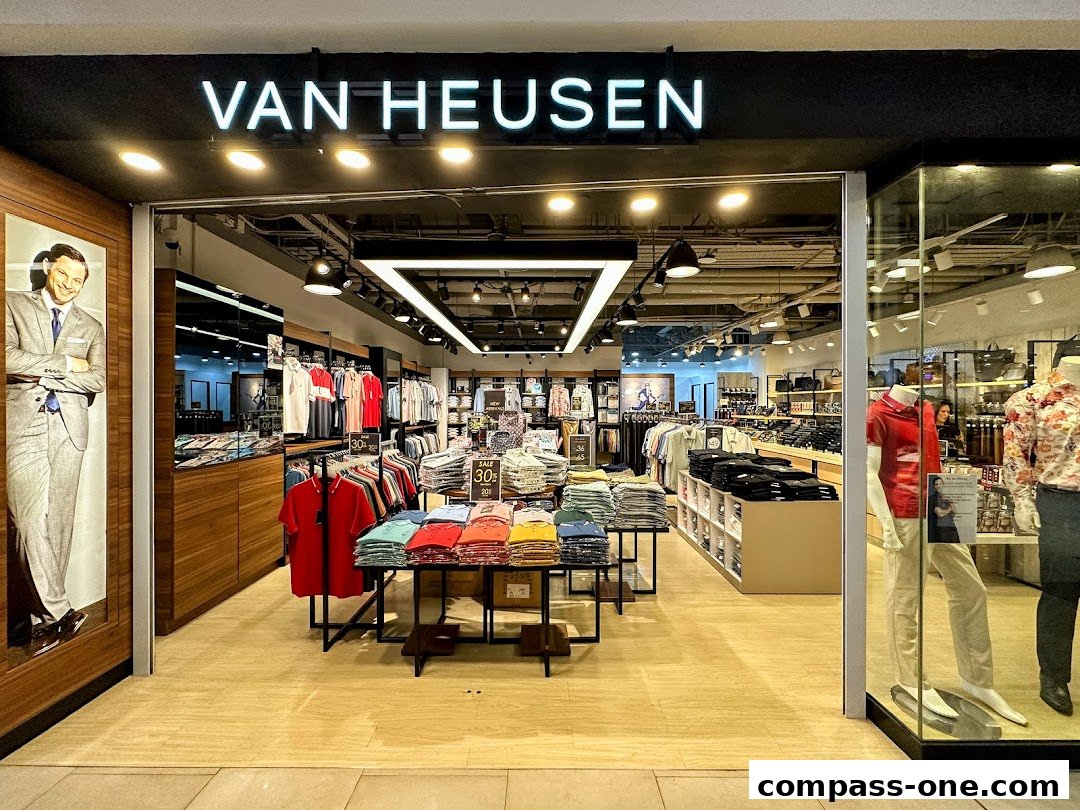 The entrance of a Van Heusen store showcasing men's apparel and sale items.