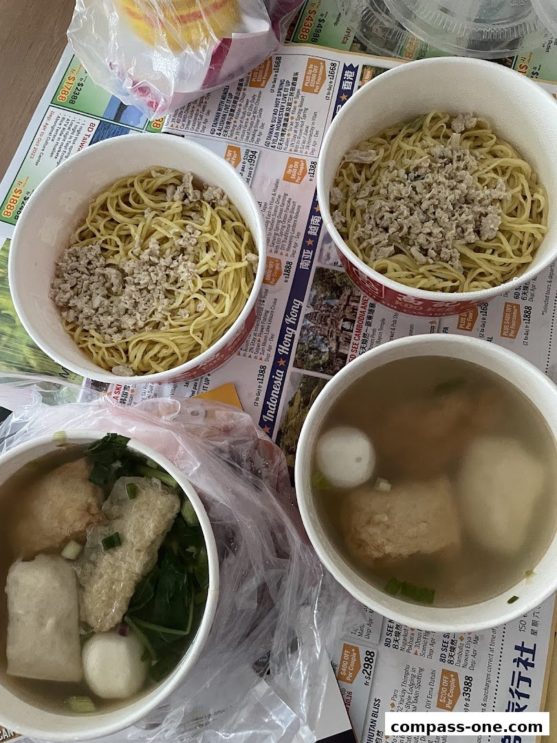 Three bowls of noodles and one bowl of soup with fish balls and vegetables.