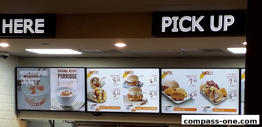 A KFC menu board displaying various meal options including porridge, twisters, burgers, platters, and pancakes.